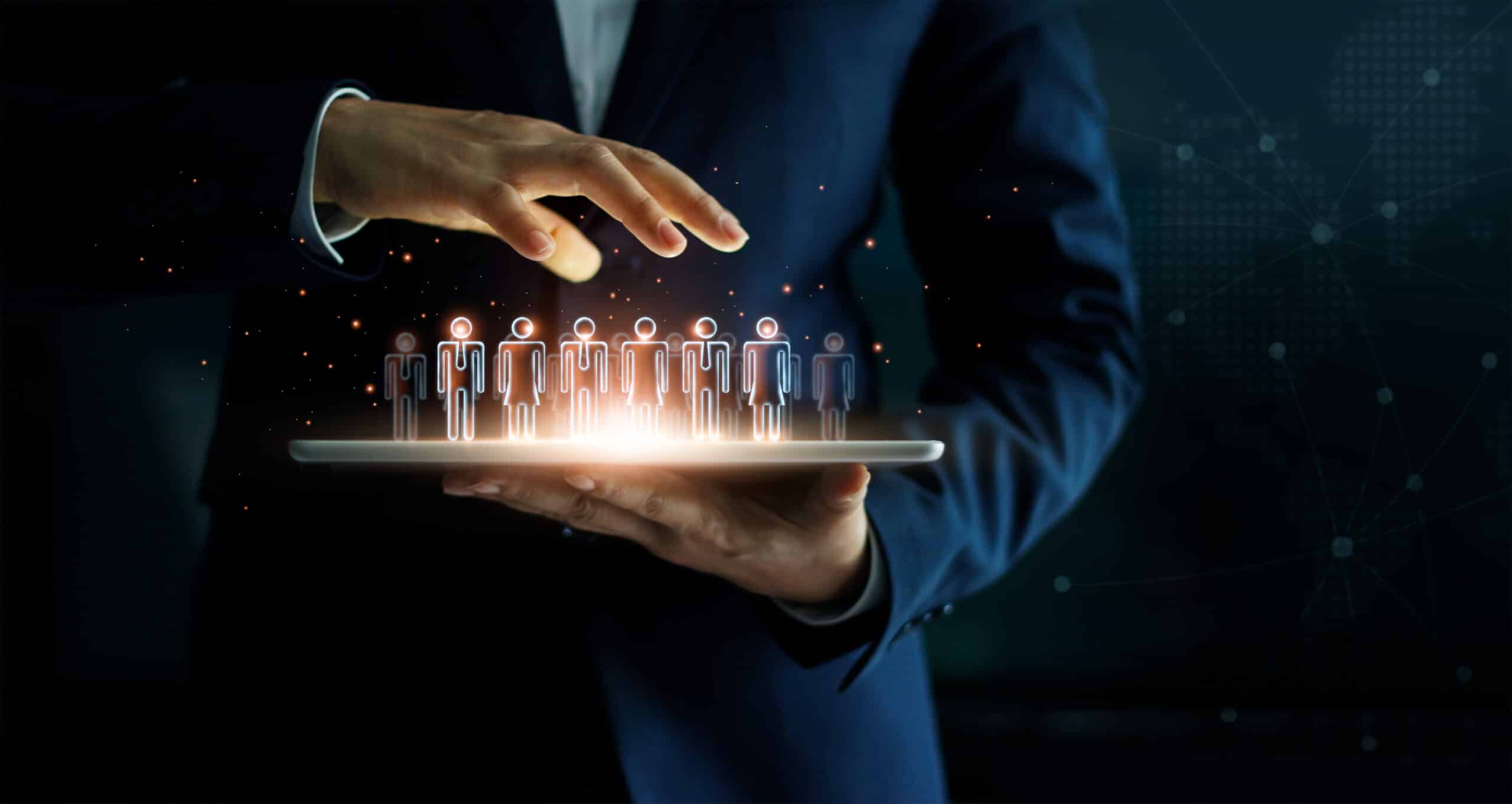 Businessman holding tablet and managing group of people in hand. Virtual icon of social network. Business technology concept.
